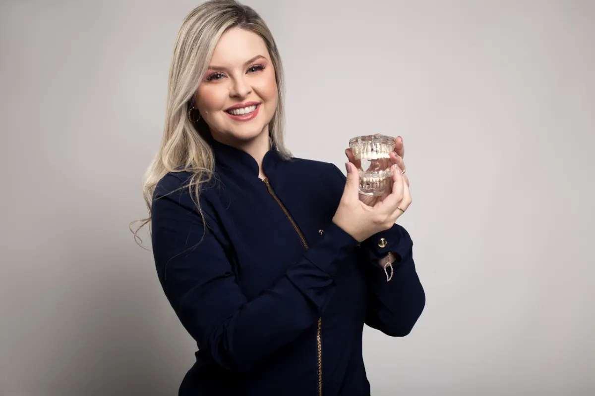 Dra. Maruza Ludvig segurando modelo de arcada dentária usado no planejamento de implantes